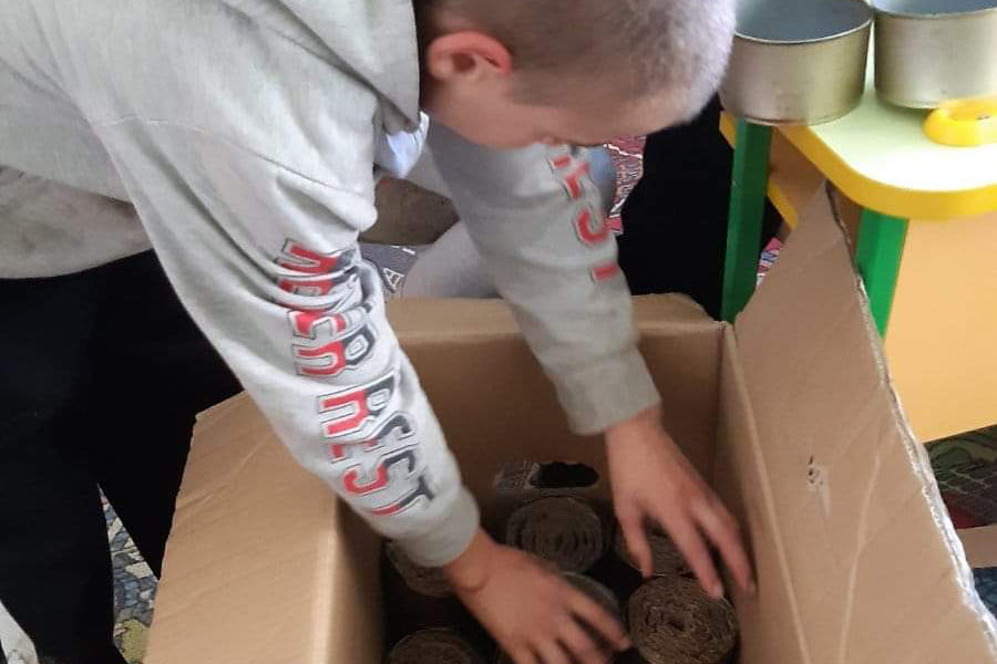 Photo of a boy reaching into a box