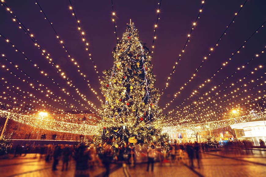 Christmas tree and lights at night in Kyiv with people in blurred motion